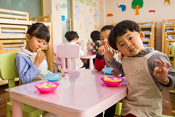 Three children eating in classroom
