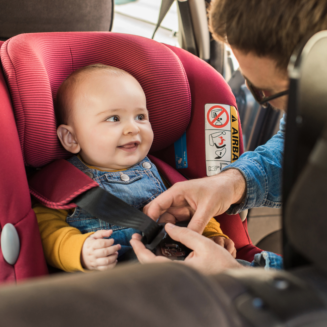 Baby smiling in safe car seat